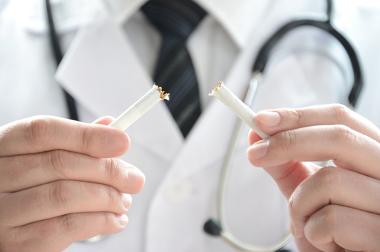 Doctor is breaking up cigarettes; showing how bad nicotine is for you.